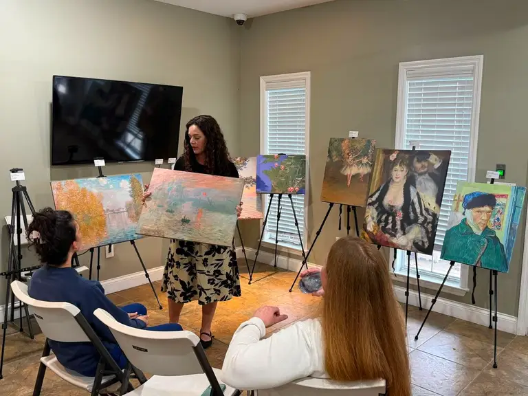 DOCENT presenter holding a life-size Monet replica up close for the audience
